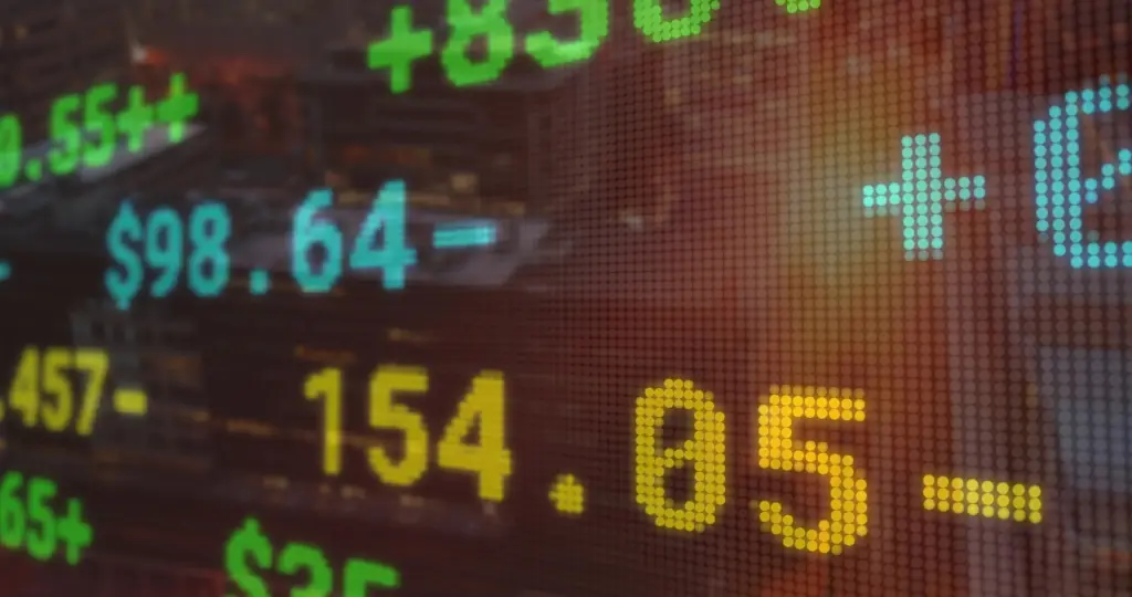 Close-up of a digital stock ticker with green, blue, and yellow numbers scrolling on a grid-like display.
