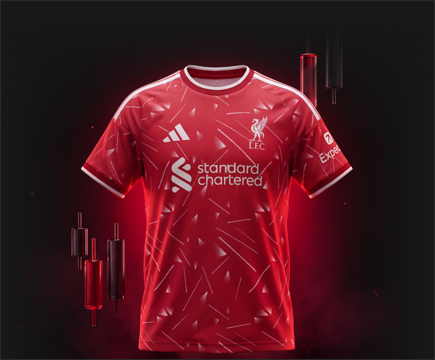 Liverpool FC red home jersey with white trim and geometric pattern, sponsor 'standard chartered' on chest, crest on left.
